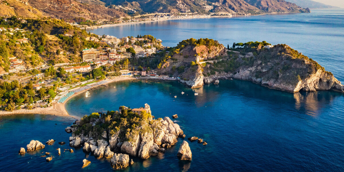 Eine Luftaufnahme von der Italienischen Küste mit vielen Felsen, Häusern und dem Meer.
